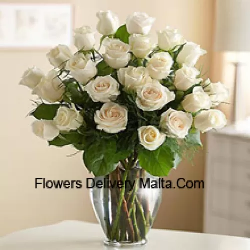 25 roses blanches avec quelques fougères dans un vase en verre