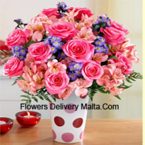 Roses roses, orchidées roses et fleurs pourpres assorties arrangées magnifiquement dans un vase en verre