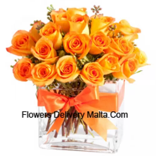 25 Roses Orange avec quelques fougères dans un vase en verre